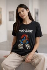 Woman sitting outdoors wearing a black cotton t-shirt featuring a blue Lord Shiva Mahakal graphic