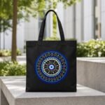 Black canvas tote bag with blue and white Boho Evil Eye mandala graphic – spiritual aesthetic shoulder bag