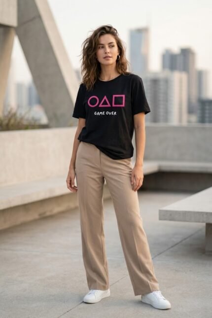 Woman standing outdoors wearing a black cotton t-shirt featuring the iconic Squid Game circle, triangle, and square symbols