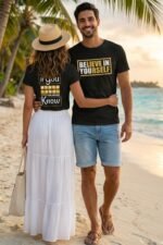Couple walking outdoors with the man wearing a black cotton t-shirt featuring the motivational quote Believe in Yourself