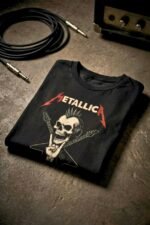 Flat lay of a black cotton t-shirt featuring an edgy Metallica skull graphic styled with headphones