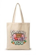 Natural cream canvas tote bag with "SomeTeddy Loves You" graphic – cute gift accessory to pair with a faith-inspired black t-shirt