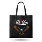 Black canvas tote bag with "Be You" eagle graphic – empowering accessory to pair with a Love Bangla Tee