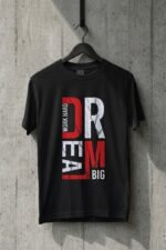 Black cotton t-shirt hanging on a wooden hanger featuring the vertical Dream Big typography graphic