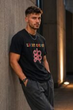 Cinematic studio portrait of a male model wearing the Pitch Black Lucky Energy Streetwear Tee.