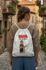 Streetwear lifestyle view of a man wearing an olive green jacket carrying a white canvas drawstring bag with a funny Desi meme graphic.