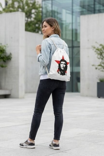 An alternative streetwear style mockup of the Che Guevara portrait drawstring sackpack leaning against a colorful graffiti wall.