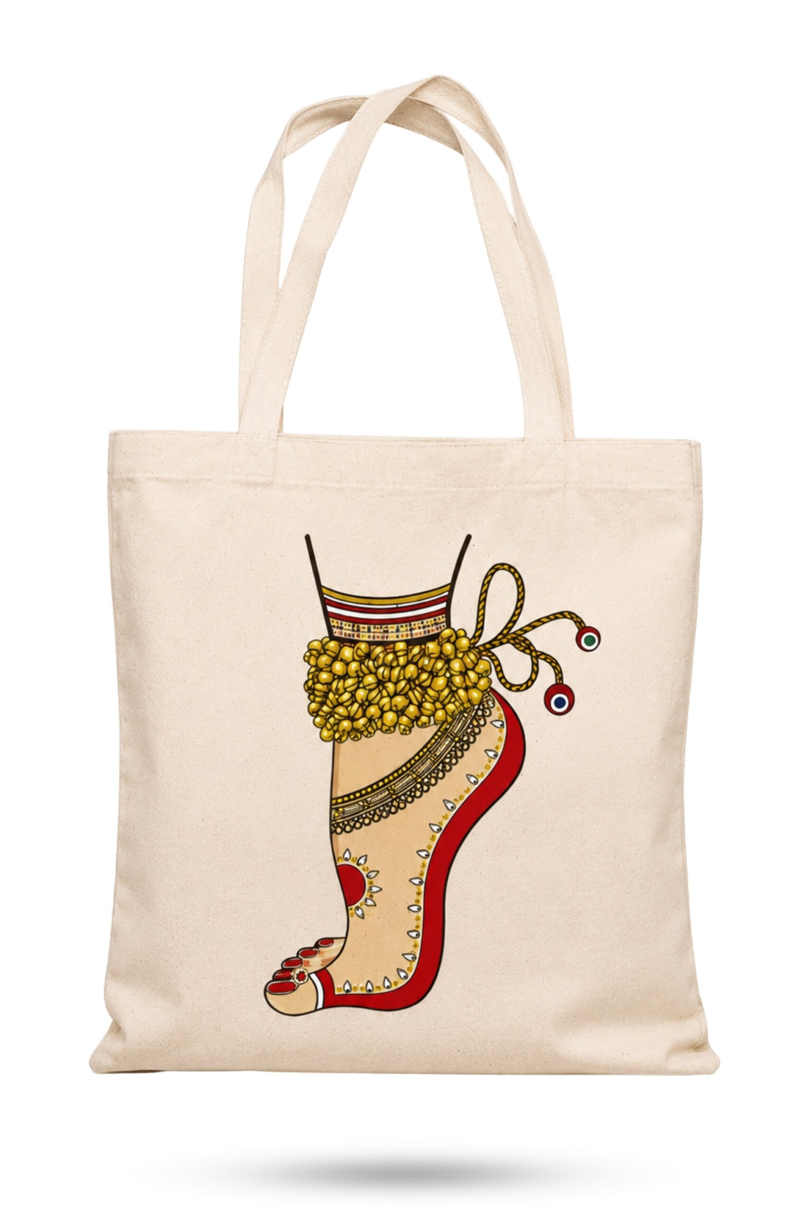 main image Off-white canvas tote bag featuring an Indian classical dancer foot adorned with golden ghungroo bells, red alta dye, and ornamental anklet with zipper closure.