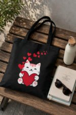 Cute chibi white kitten black canvas tote bag flat lay on rustic wooden table