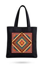 Midnight black heavy-duty cotton canvas tote bag featuring an intricate bohemian folk art mandala print in terracotta, mustard, and teal with reinforced shoulder straps.
